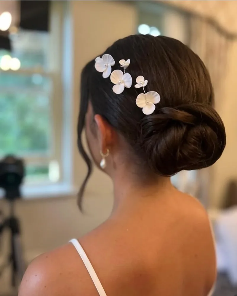 Soft low bridal bun with white flower pins at Ballyseede Castle, Tralee
